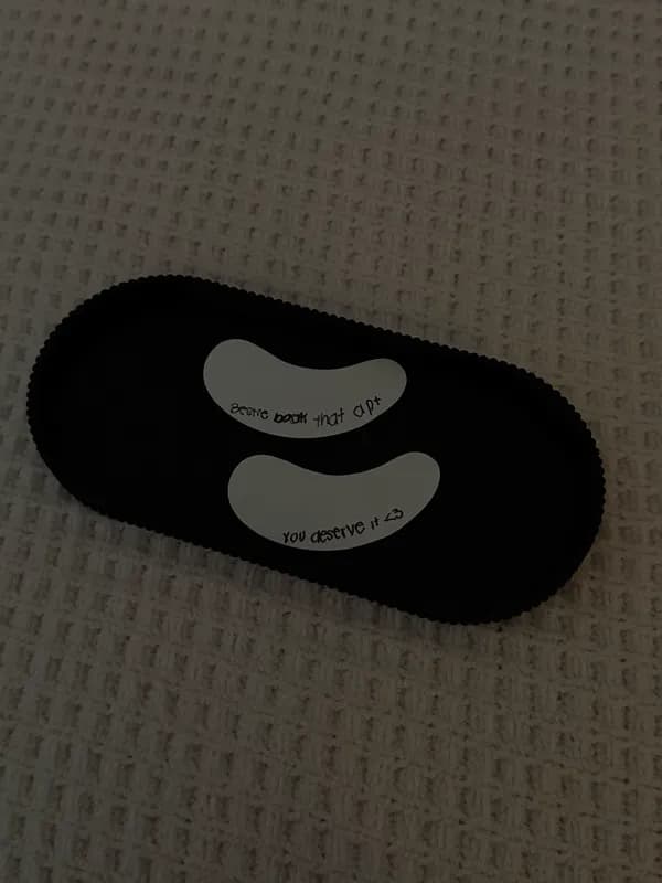 Under-eye gel pads on a black tray with a handwritten note that reads you deserve it